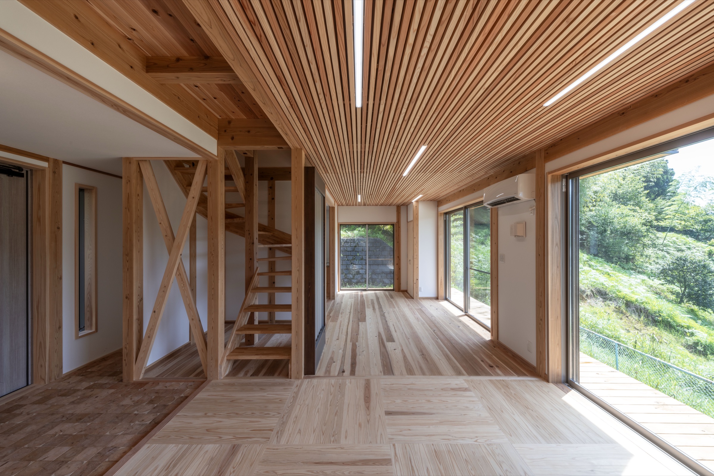 木の天井ルーバーが印象的な住宅内観